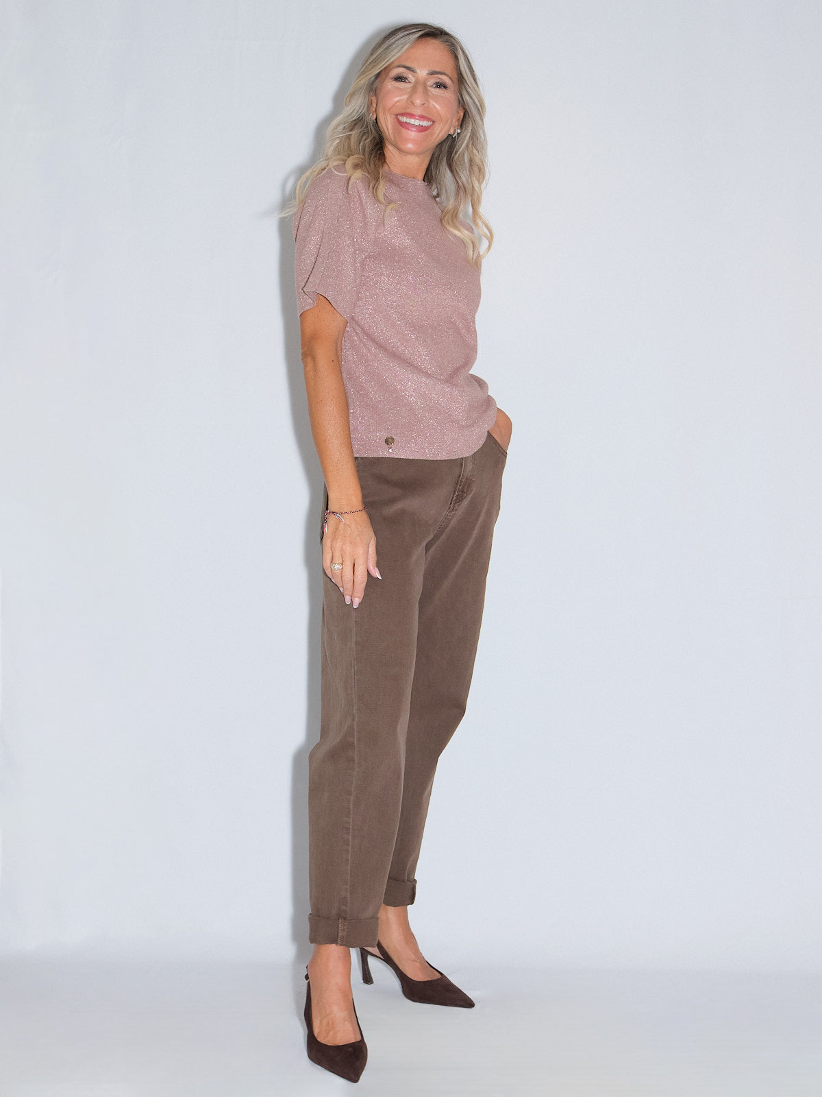 Girocollo mezza manica lurex in rosa indossato con pantaloni marroni e tacchi, perfetto per ogni guardaroba.
