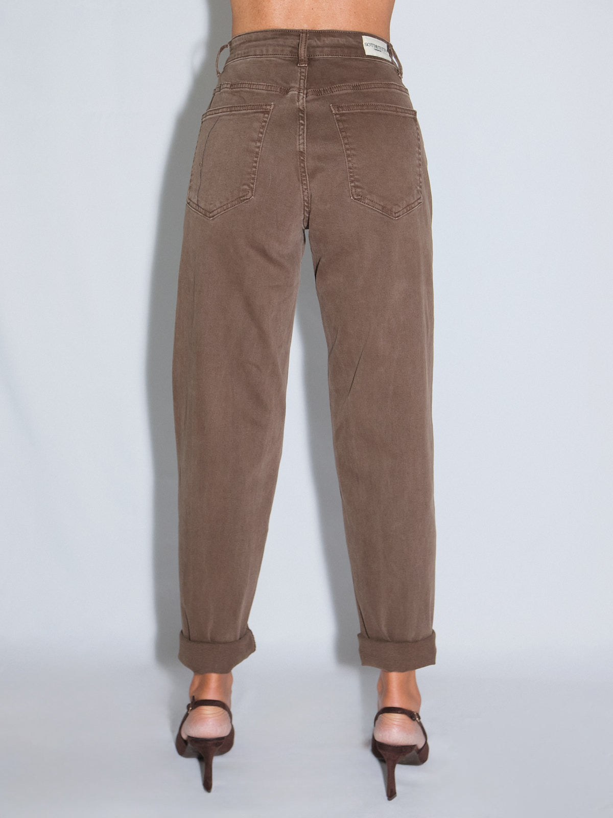 Pantalone gamba dritta in color cioccolato visto da dietro, con vestibilità push up e dettagli elasticizzati.