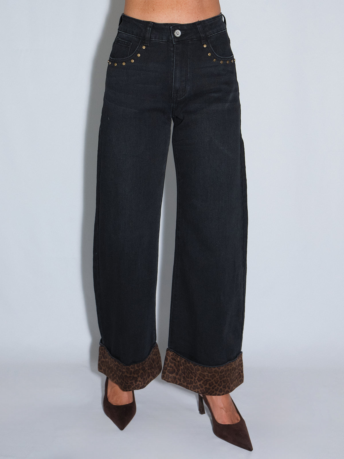 Jeans con risvolto maculato, elasticizzati e larghi alla caviglia, con dettagli borchiati e risvolto animalier.
