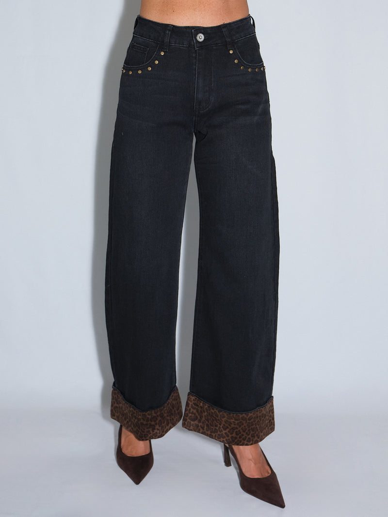 Jeans con risvolto maculato, elasticizzati e larghi alla caviglia, con dettagli borchiati e risvolto animalier.