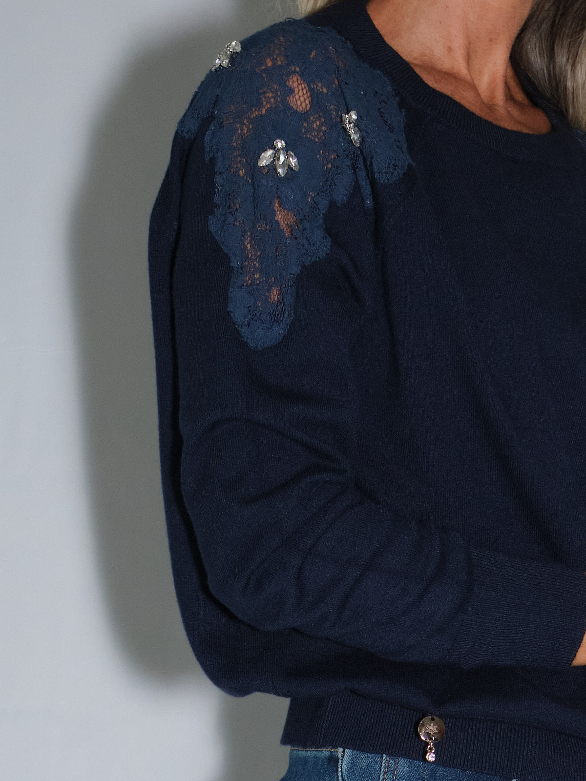Maglia con inserti in pizzo, girocollo blu scuro con applicazioni di pizzo e fiori in Swarovski sulle spalle.