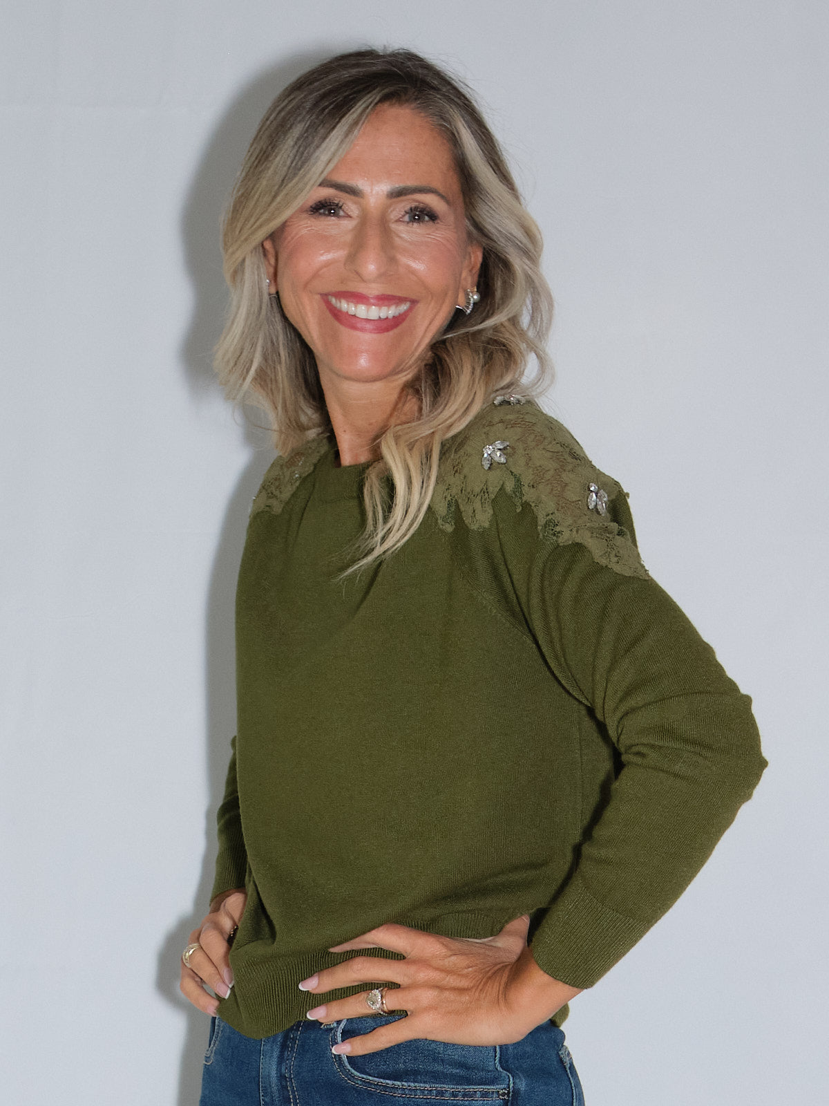 Maglia con inserti in pizzo, maglia girocollo verde con applicazioni di fiori in Swarovski e inserti in pizzo.