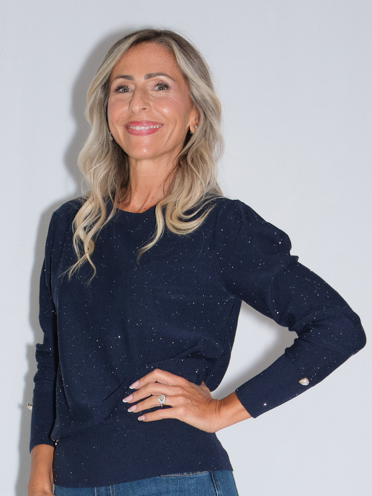 Girocollo manica lunga lurex in blu con dettagli di bottoncini, indossato da donna sorridente.