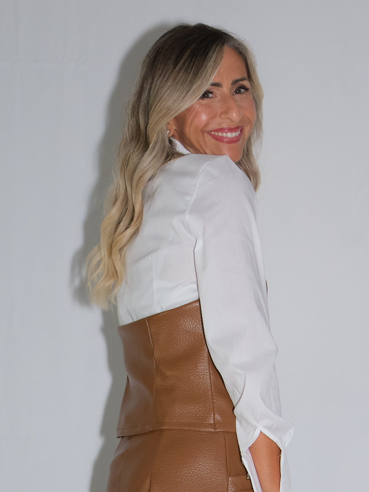 Gilet in ecopelle worn by a model, showcasing the back design with two front buckles.