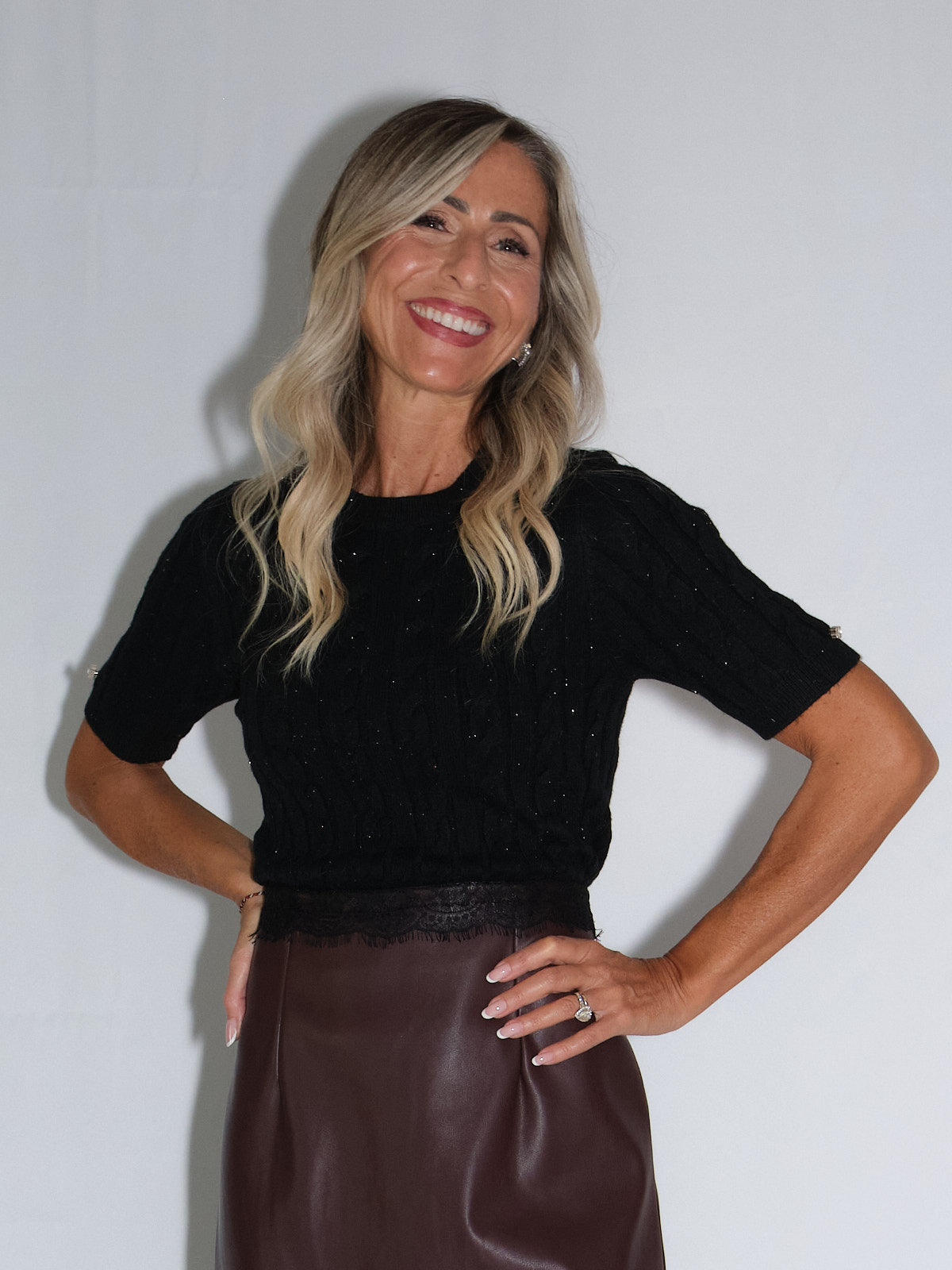 Girocollo mezza manica con trecce, elegante e quotidiano, indossato da donna con gonna in pelle.