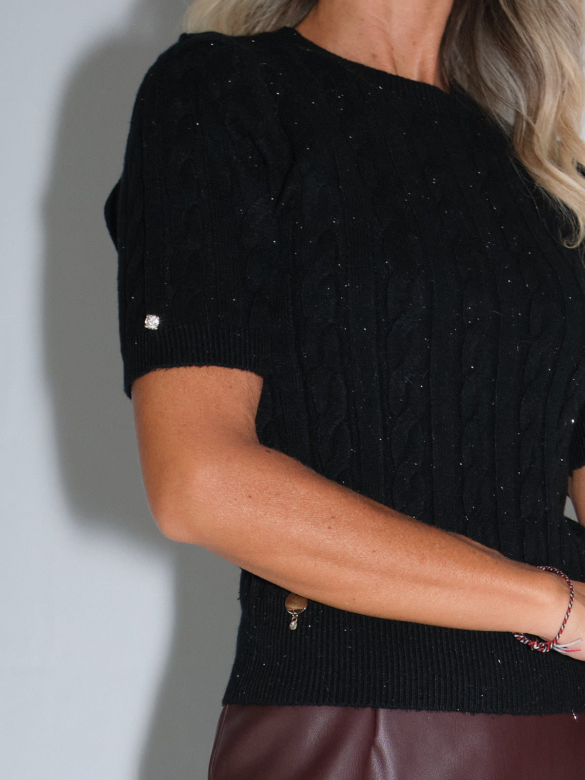 Girocollo mezza manica con trecce, elegante top nero con dettagli glitterati, perfetto per abbinamenti casual e chic.