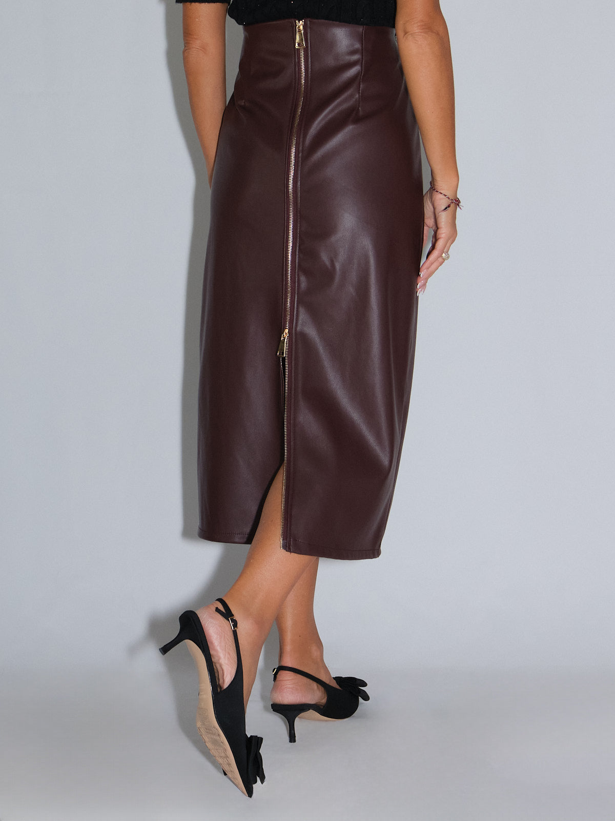 Tubino in ecopelle bordeaux con zip posteriore e spacco, dettagli di pizzo elegante, stile rock-chic.